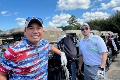 Two-men-standing-with-golf-carts-998